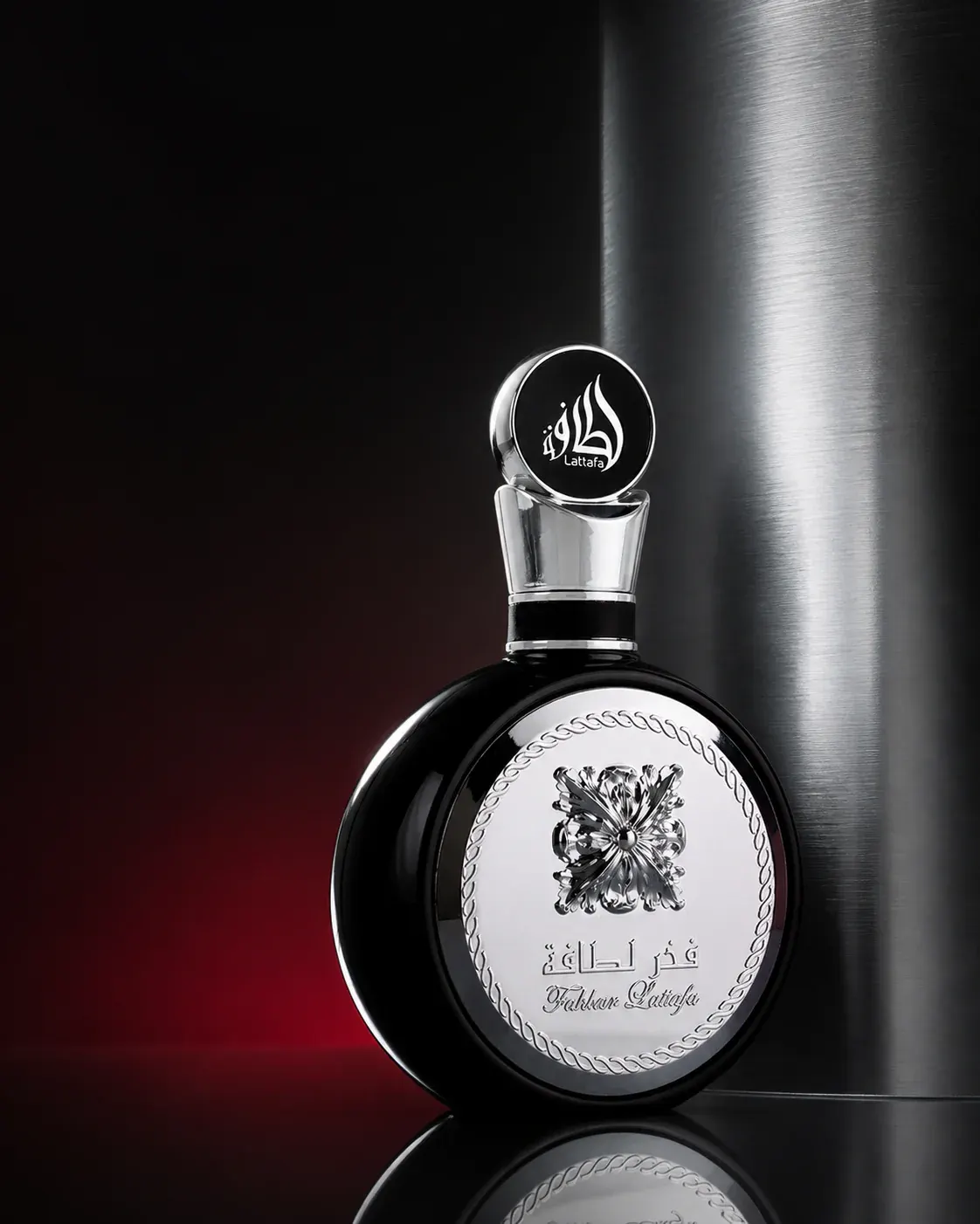 Fakhar Black bottle against brushed steel and deep red light